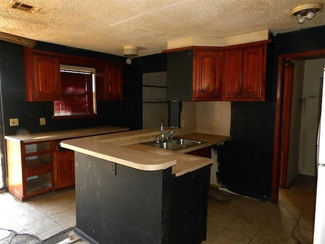 kitchen featuring sink, kitchen peninsula, and a textured ceiling