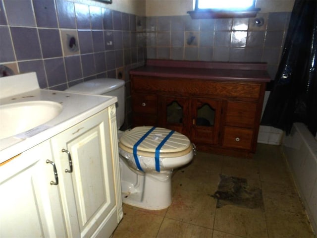 bathroom featuring tile walls, vanity, tile patterned flooring, and toilet