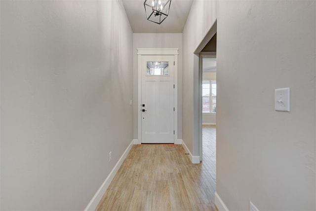 entryway featuring an inviting chandelier and light hardwood / wood-style flooring