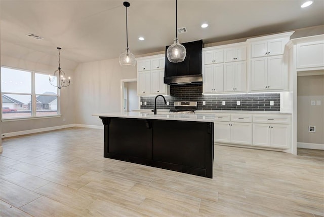 kitchen with sink, white cabinetry, a center island with sink, stainless steel electric range oven, and decorative light fixtures