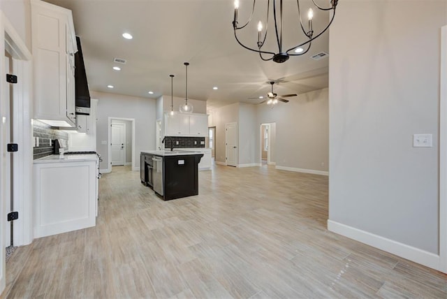 kitchen featuring white cabinetry, tasteful backsplash, a center island with sink, pendant lighting, and ceiling fan