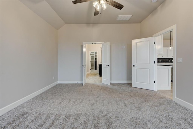 unfurnished bedroom featuring ceiling fan, light colored carpet, and lofted ceiling