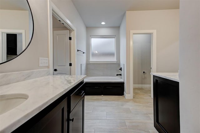 bathroom featuring vanity and a washtub