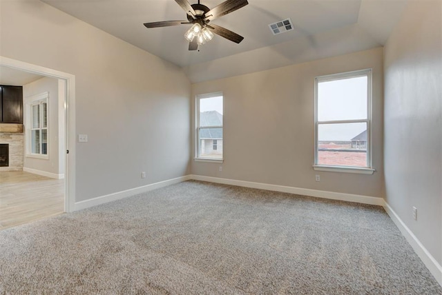 spare room with vaulted ceiling, light carpet, and ceiling fan