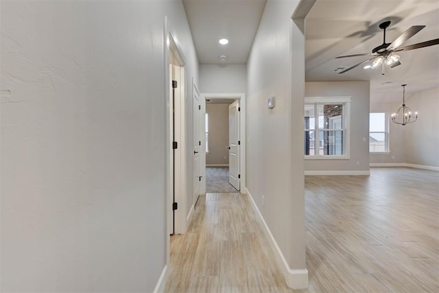 hall featuring an inviting chandelier and light hardwood / wood-style floors