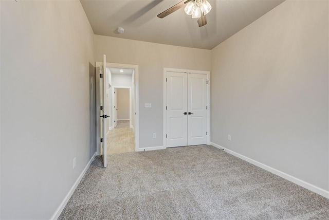 unfurnished bedroom featuring light carpet, a closet, and ceiling fan