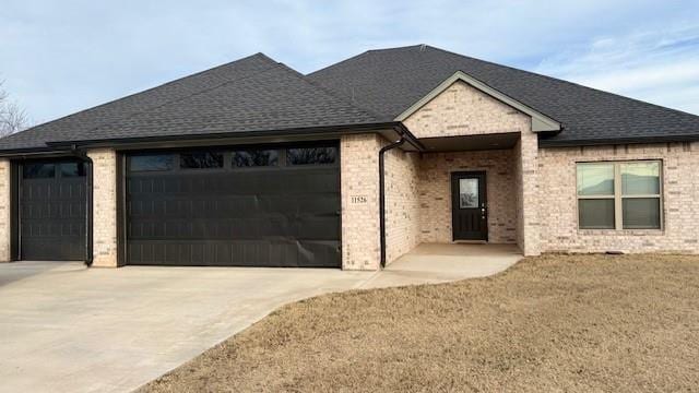 view of front of house featuring a garage and a front lawn