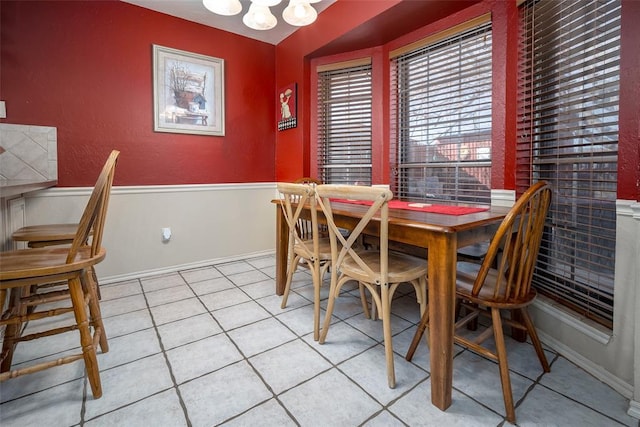 tiled dining space featuring a notable chandelier