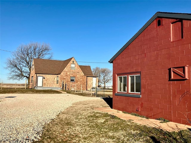 view of property exterior featuring concrete block siding and driveway