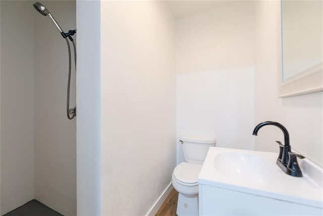 bathroom with toilet, wood finished floors, and vanity