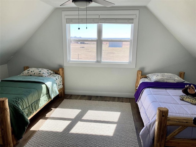 bedroom with a ceiling fan, baseboards, vaulted ceiling, and wood finished floors