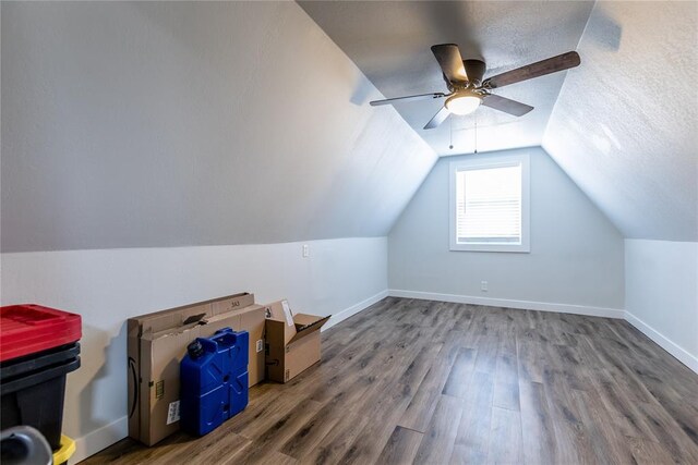 bonus room with lofted ceiling, a textured ceiling, baseboards, and wood finished floors