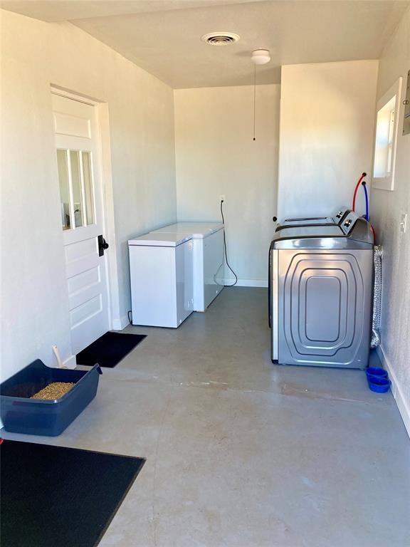 clothes washing area featuring laundry area, washing machine and dryer, visible vents, and baseboards