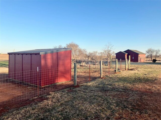 view of outdoor structure featuring fence and an outbuilding