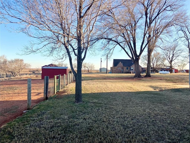 view of yard with an outbuilding, a pole building, and fence