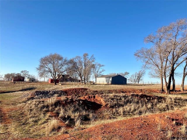 view of yard with an outbuilding, a rural view, and an outdoor structure