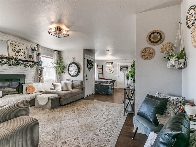 living room with a fireplace, hardwood / wood-style floors, and a textured ceiling