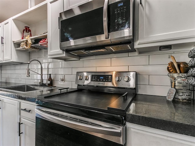 kitchen featuring white cabinetry, stainless steel appliances, sink, and tasteful backsplash