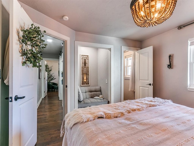 bedroom with dark hardwood / wood-style floors and a chandelier