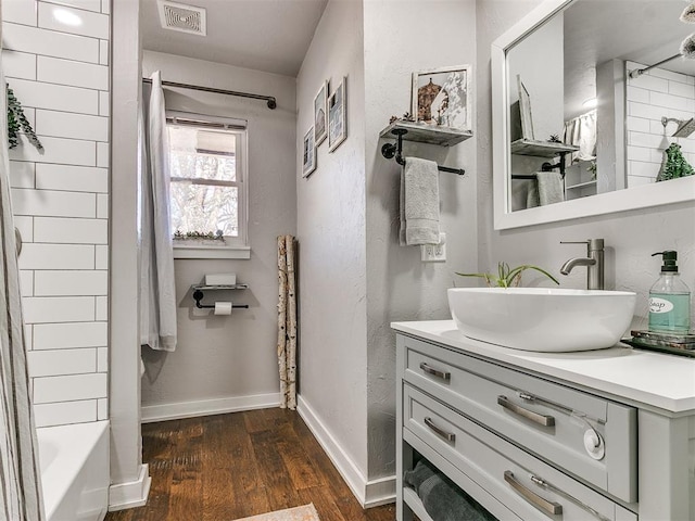 bathroom featuring hardwood / wood-style flooring, vanity, and tub / shower combination