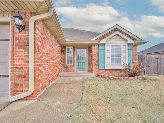 doorway to property featuring a garage and a lawn