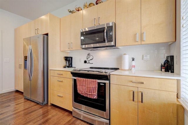 kitchen featuring stainless steel appliances and light brown cabinets