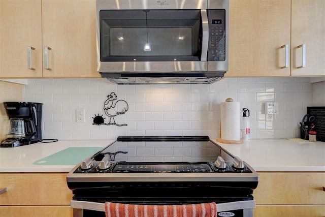 kitchen featuring appliances with stainless steel finishes, light brown cabinets, and backsplash