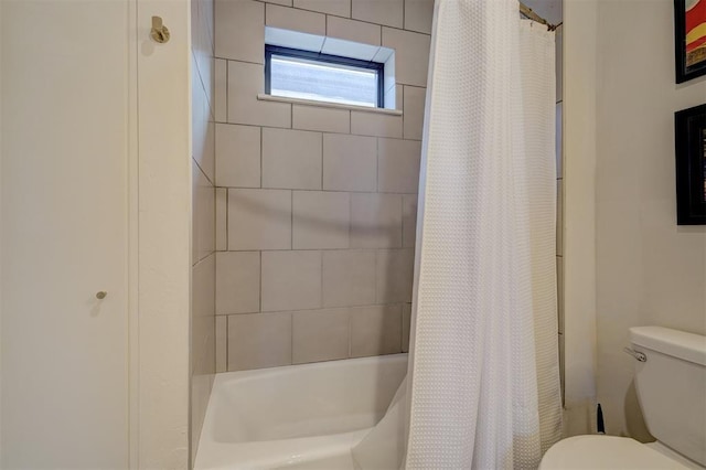 bathroom featuring shower / tub combo with curtain and toilet