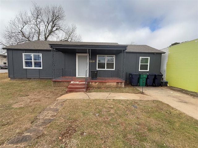 view of front of house with crawl space, covered porch, a shingled roof, and a front lawn