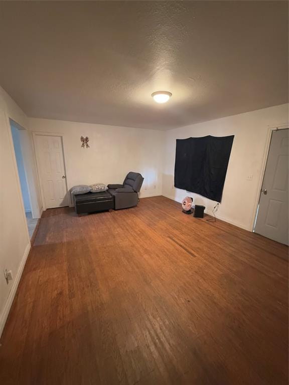 living area with a textured ceiling and wood finished floors