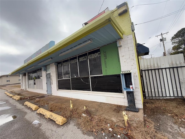 view of property exterior featuring concrete block siding and fence