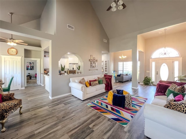 3629 W County Street 2850th St, Ninnekah, OK 73067 - living area with visible vents, baseboards, wood finished floors, ceiling fan with notable chandelier, and high vaulted ceiling