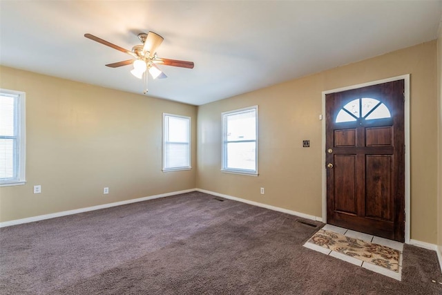 foyer entrance featuring ceiling fan and carpet flooring