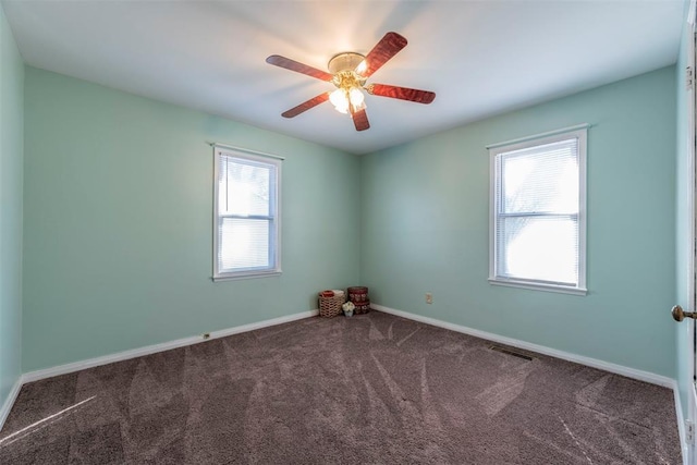 carpeted spare room featuring ceiling fan