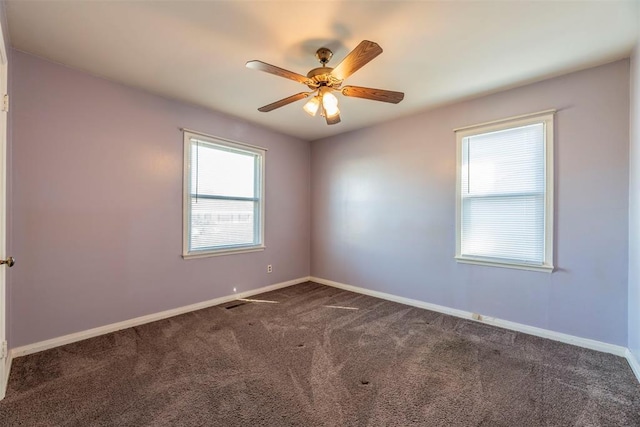 unfurnished room featuring dark colored carpet, plenty of natural light, and ceiling fan