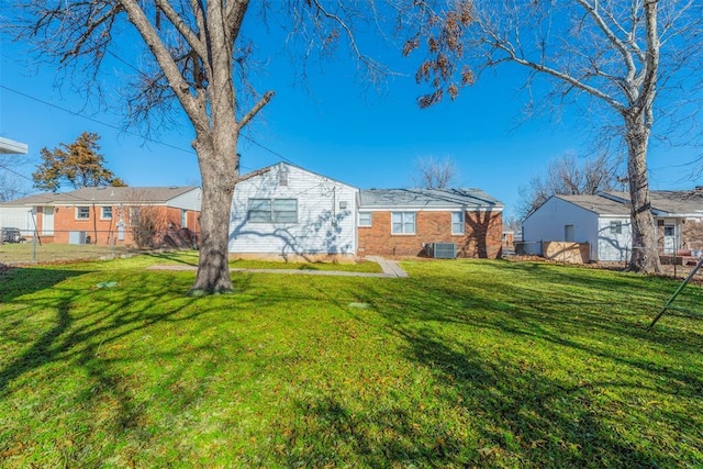 exterior space with central AC unit and a lawn