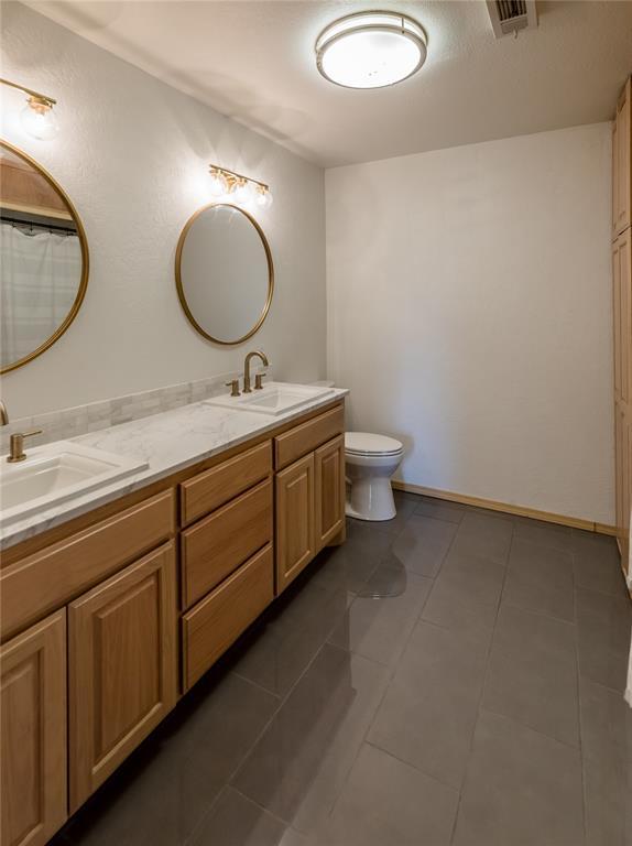 bathroom with vanity, tile patterned floors, and toilet