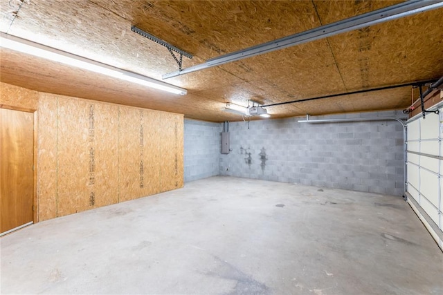 garage with a garage door opener and electric panel