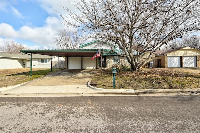 ranch-style home featuring an outbuilding, a garage, and a carport