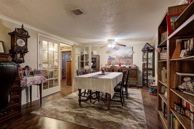 dining area with ceiling fan, crown molding, dark wood-type flooring, a textured ceiling, and french doors