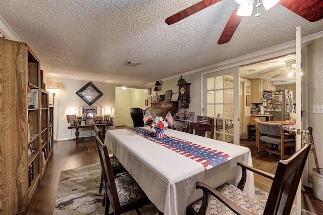 dining area with crown molding, dark wood-type flooring, a textured ceiling, and ceiling fan