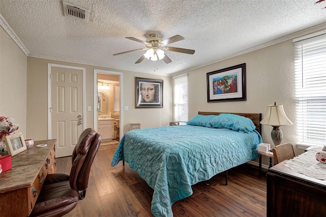 bedroom with crown molding, ensuite bath, a textured ceiling, dark hardwood / wood-style floors, and ceiling fan