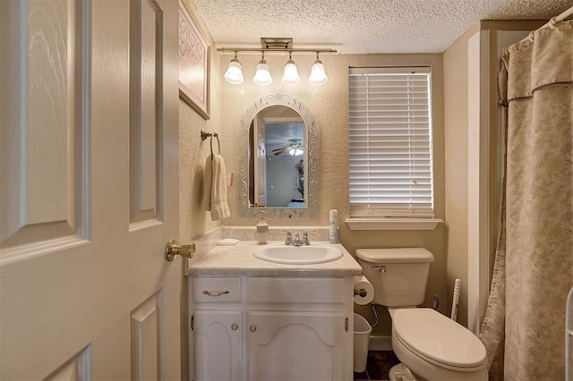 bathroom featuring vanity, a textured ceiling, and toilet