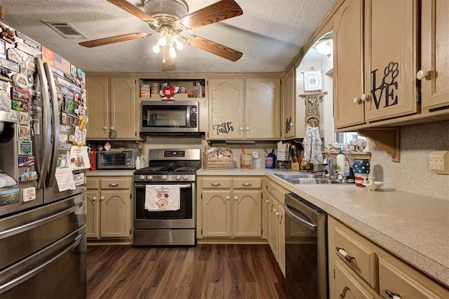 kitchen with appliances with stainless steel finishes, sink, dark wood-type flooring, and a textured ceiling