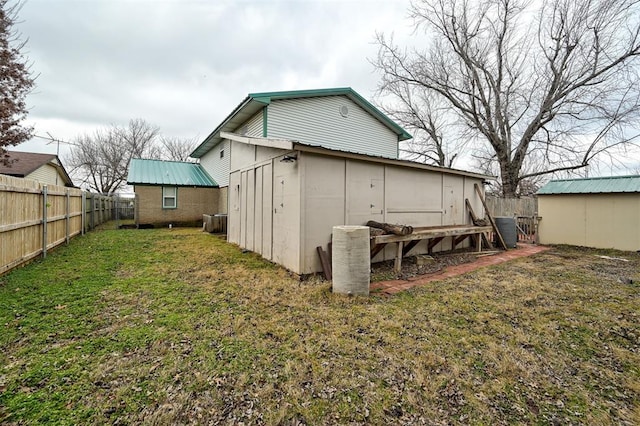 back of property with a storage shed and a lawn