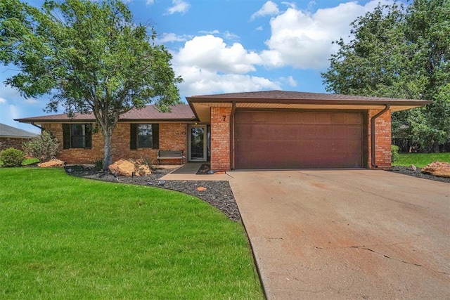 ranch-style home featuring a garage and a front lawn