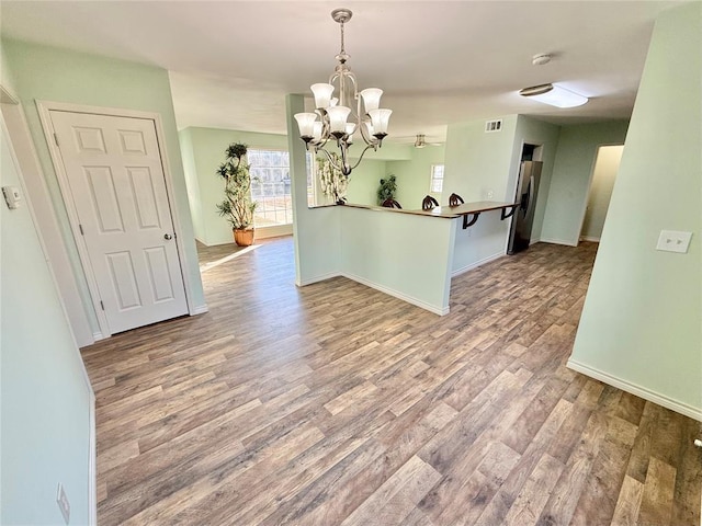 unfurnished dining area featuring a chandelier and light hardwood / wood-style flooring