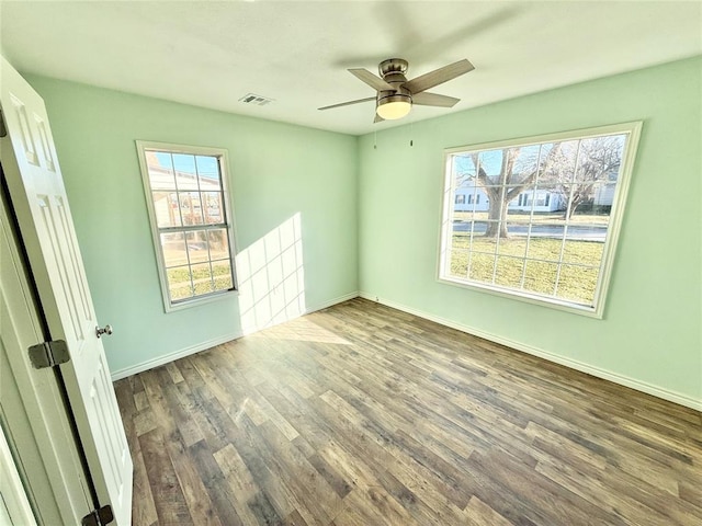 empty room featuring hardwood / wood-style flooring, ceiling fan, and plenty of natural light