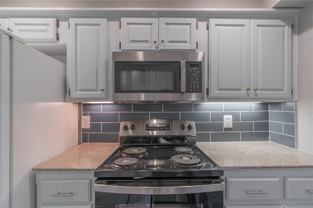 kitchen featuring backsplash, light stone countertops, and appliances with stainless steel finishes