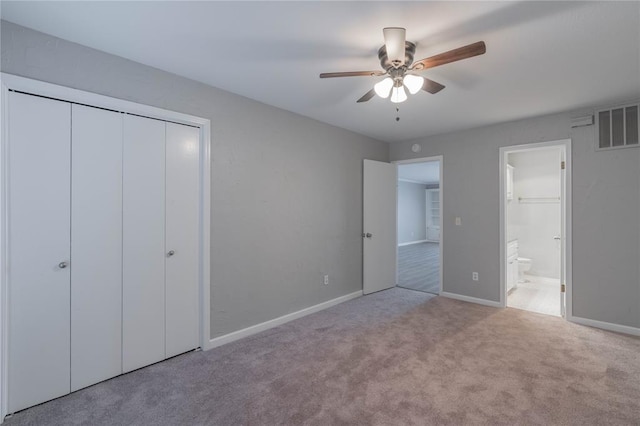 unfurnished bedroom with light carpet, connected bathroom, a closet, and ceiling fan